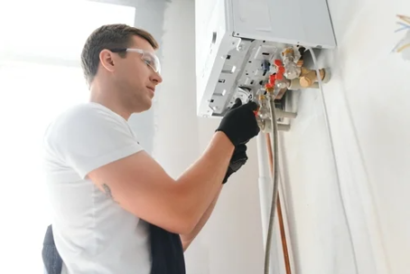 A man working on a tankless water heater